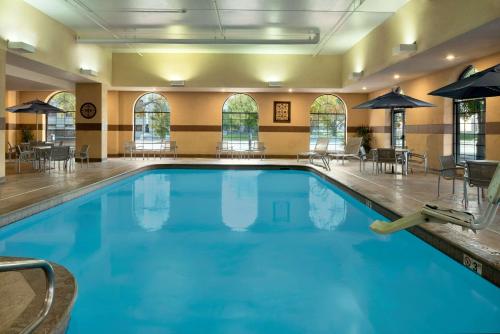 a large pool in a hotel with tables and chairs at Embassy Suites Des Moines Downtown in Des Moines