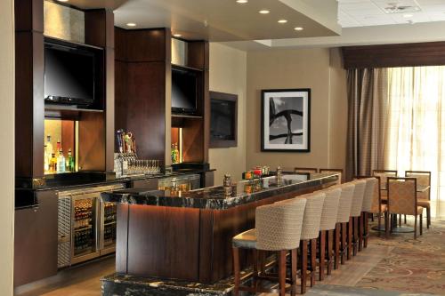 a bar in a hotel room with a bunch of chairs at Embassy Suites Des Moines Downtown in Des Moines