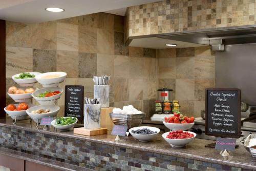 a counter with bowls of fruits and vegetables on it at Embassy Suites Des Moines Downtown in Des Moines