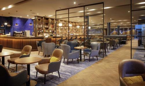 a restaurant with tables and chairs and a bar at Hilton Dublin Airport in Cloghran