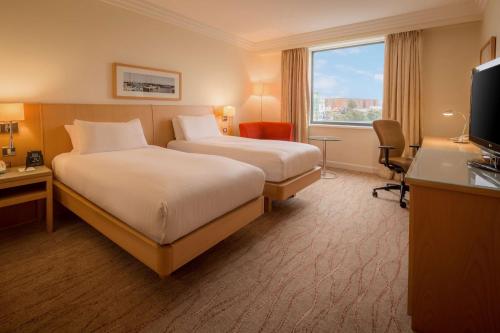 a hotel room with two beds and a window at Hilton Dublin Airport in Cloghran