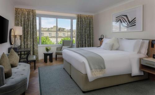 sypialnia z dużym białym łóżkiem i dużym oknem w obiekcie Conrad Dublin w Dublinie
