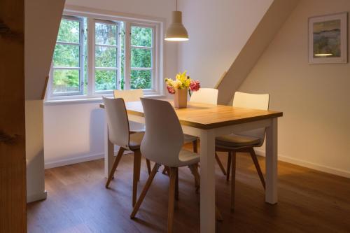 a dining room with a wooden table and chairs at Lindenhuus in Fleckeby