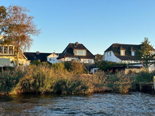 a group of houses on the banks of a river at Ferienwohnung Wassergrundstück an der Schlei in Fahrdorf