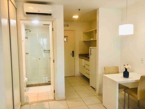 a bathroom with a shower and a kitchen with a table at V510 Maravilhoso flat em Brasília Ótima localização in Brasilia