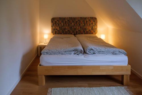 Bett in einem Zimmer mit zwei Lampen an zwei Tischen in der Unterkunft Lindenhuus in Fleckeby