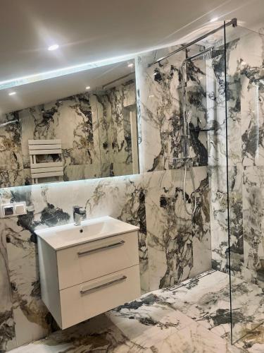 a bathroom with a sink and a shower at Apartamenty Modrzewiowa Zator in Piotrowice