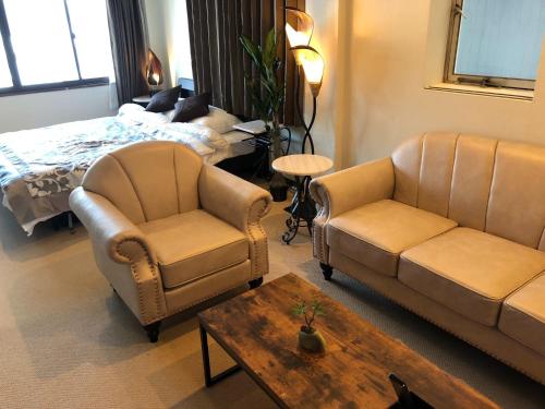 sala de estar con sofá, sillas y cama en Cool Inn Otaru - Vacation STAY 42415v, en Otaru