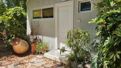 a front door of a house with potted plants at פינה בגינה יזרעאלי in ‘Amir