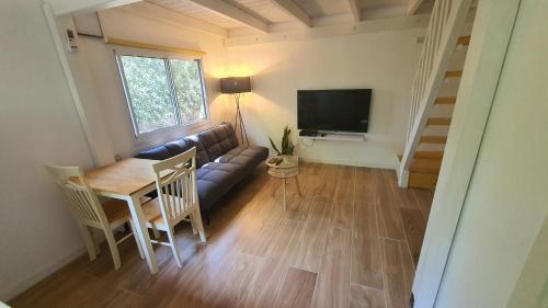 a living room with a couch and a table and a television at פינה בגינה יזרעאלי in ‘Amir