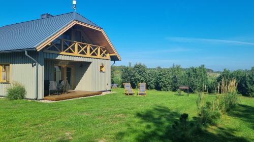a small house with a gambrel roof on a field at Smiltinas in Nidden