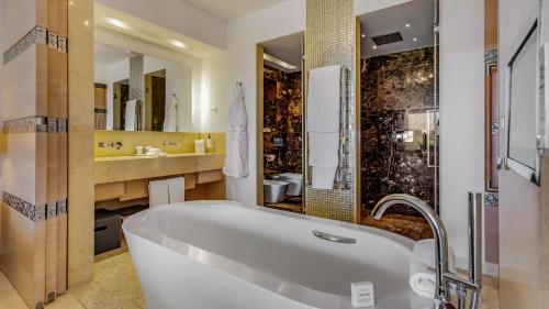 a bathroom with a tub and a sink and a mirror at Conrad Algarve in Quinta do Lago
