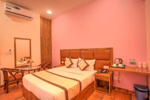 グレーター・ノイダにあるStiltstay Hotel, Greater Noidaのベッドルーム(大型ベッド1台、テーブル付)