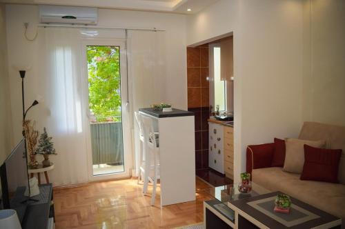 - un salon avec un canapé et une fenêtre dans l'établissement River Site Lux Apartment, à Podgorica
