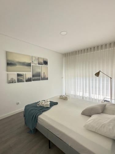 a white bedroom with a large bed and a window at Douro Escape - Riverfront Apartment in Peso da Régua