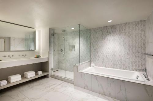 a white bathroom with a tub and a shower at Hilton Fort Collins in Fort Collins