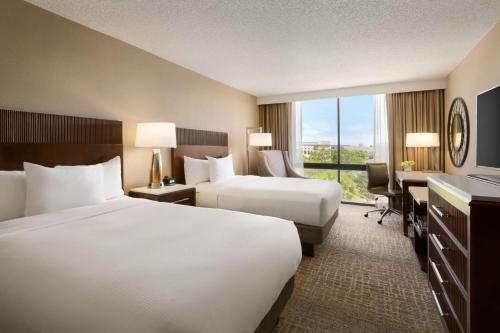Habitación de hotel con 2 camas y escritorio en Hilton Fort Collins, en Fort Collins