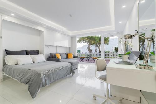 a bedroom with a bed and a desk with a laptop at Holiday Home Luxury Loft GC in Maspalomas