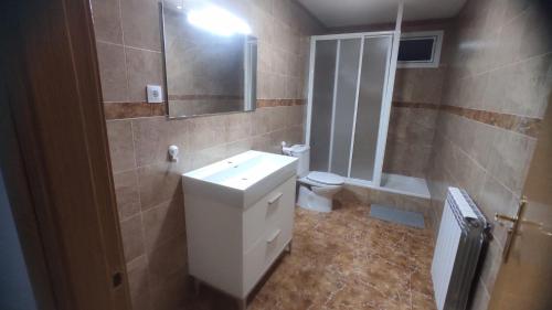 uma casa de banho com um lavatório, um WC e um espelho. em Casa en zona rural a 200 m de Ariño (Teruel) em Ariño