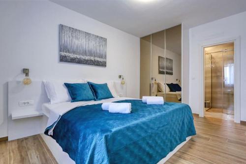 ein Schlafzimmer mit einem großen Bett mit blauer Bettwäsche in der Unterkunft Villa Orkula in Debeljak