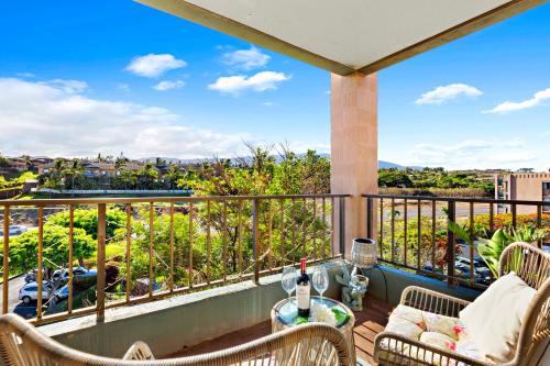 a balcony with chairs and a table with a view at Kahana Manor 619 in Kahana