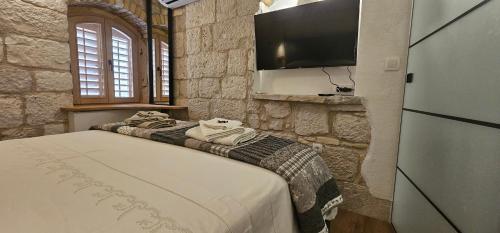 a bedroom with two beds and a flat screen tv at Magical Oasis for two in Korcula Old Town in Korčula
