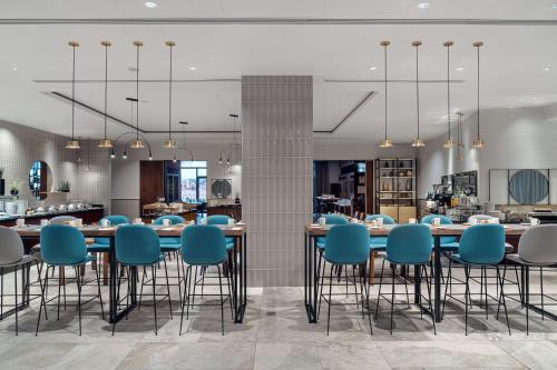 a restaurant with blue chairs and tables in a room at Hilton Gdansk in Gdańsk