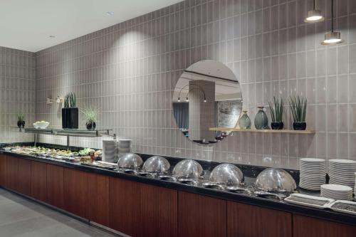 a kitchen with a counter with plates and a mirror at Hilton Gdansk in Gdańsk