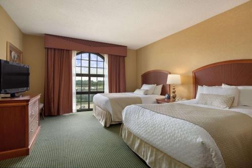 Embassy Suites by Hilton Greensboro Airport في جرينسبورو: غرفة فندقية بسريرين وتلفزيون بشاشة مسطحة