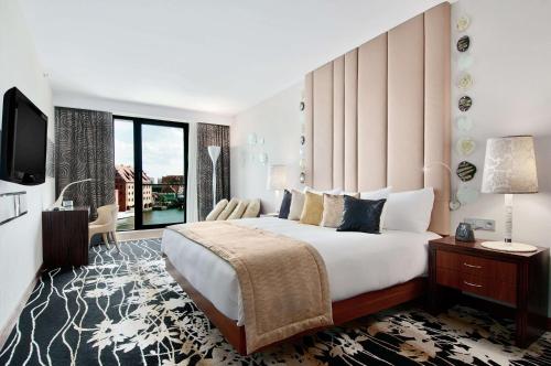 a hotel room with a large bed and a television at Hilton Gdansk in Gdańsk