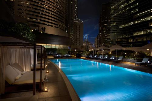 a large swimming pool in a city at night at Conrad Hong Kong in Hong Kong