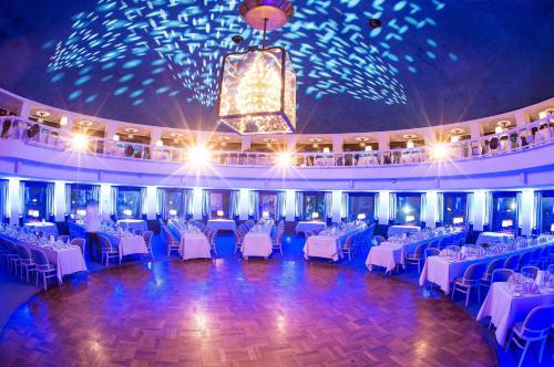 a banquet hall with white tables and chairs and a chandelier at Hilton Helsinki Kalastajatorppa in Helsinki