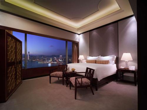a bedroom with a bed and a table with chairs at Conrad Hong Kong in Hong Kong