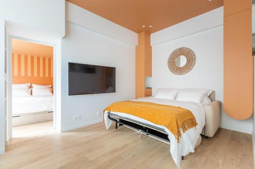 um quarto com uma cama e uma televisão na parede em Rome Batignolles - Luxe Charme - 2P em Paris