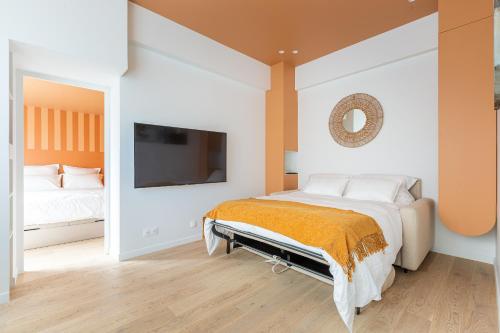 une chambre avec un lit et une télévision au mur dans l'établissement Rome Batignolles - Luxe Charme - 2P, à Paris