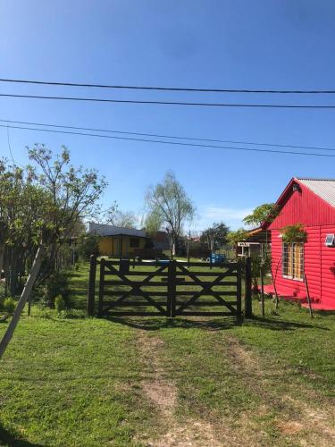 a wooden fence in front of a red barn at Cabañas AL-MA in Gualeguay