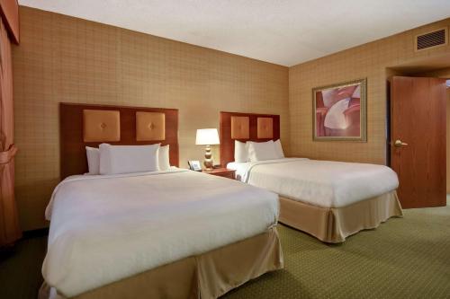 um quarto de hotel com duas camas com lençóis brancos em Embassy Suites Hot Springs - Hotel & Spa em Hot Springs