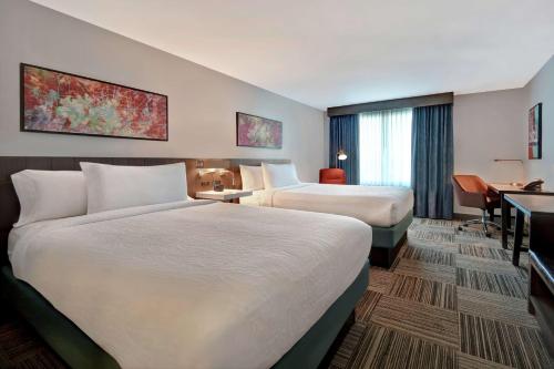 a hotel room with two beds and a desk at Hilton Garden Inn Houston/Galleria Area in Houston