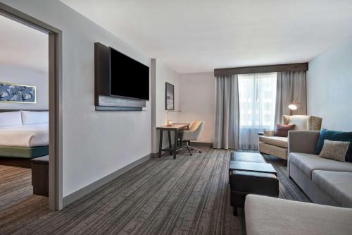 a hotel room with a bed and a living room at Hilton Garden Inn Houston/Galleria Area in Houston