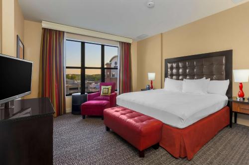 Hilton Promenade Branson Landing في برانسون: غرفه فندقيه سرير كبير وتلفزيون
