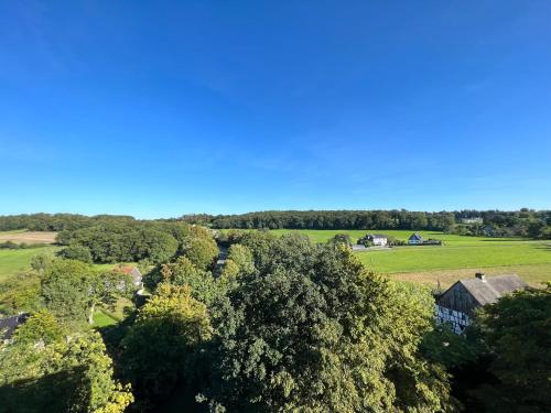 une vue aérienne sur une ferme avec des arbres et des maisons dans l'établissement Stilvolles Apartment mit ländlichem Ausblick, à Hattingen