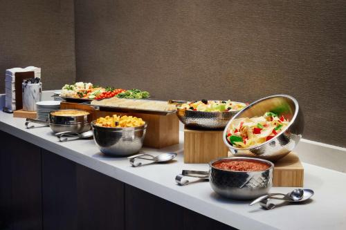 a buffet with bowls of food on a table at Embassy Suites Huntsville in Huntsville