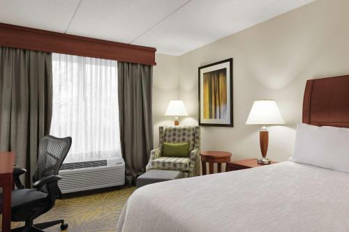 une chambre d'hôtel avec un lit et une chaise dans l'établissement Hilton Garden Inn Shelton, à Shelton