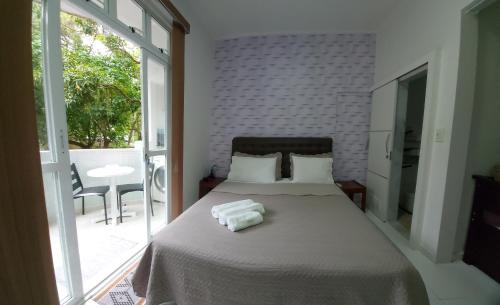 a bedroom with a bed with two towels on it at Loft aconchegante no Leblon in Rio de Janeiro
