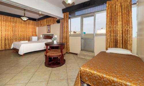 Habitación de hotel con 2 camas y ventana en Hotel Malecon Inn, en Guayaquil