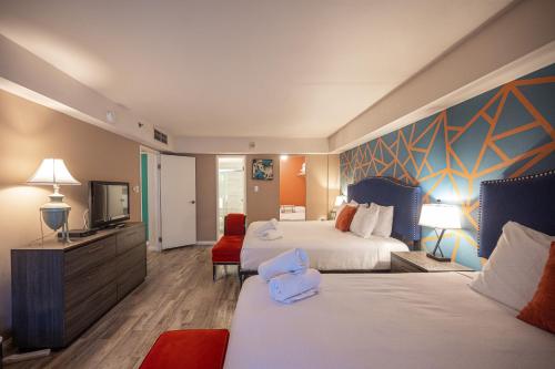 a hotel room with two beds and a flat screen tv at StayTogetherSuites 760 in Las Vegas