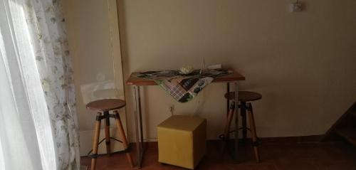 a small table and two stools in a room at Villa house Beach house N Hrakleia Xalkidikis No4 in Nea Iraklia