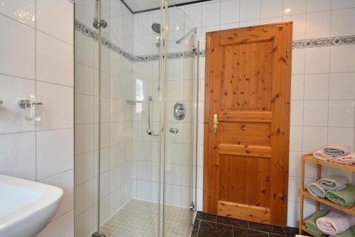 a bathroom with a shower with a wooden door at Ferienwohnung Jägerweg in Westoverledingen