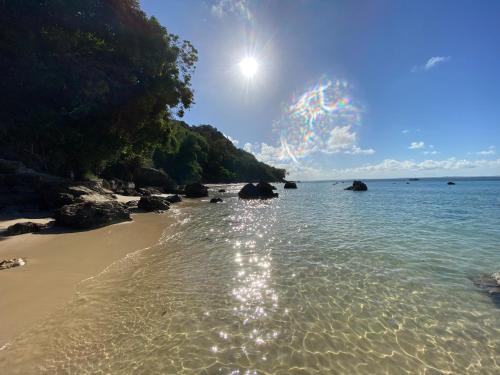 a beach with the sun reflecting in the water at Pousada Colibri in Morro de São Paulo