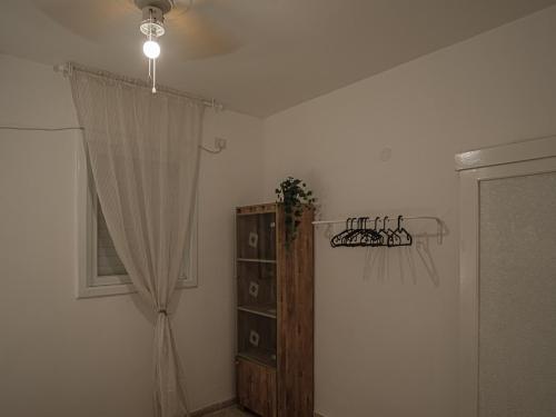a room with a curtain and a shelf and a window at Appartement cosy sur Netanya in Netanya